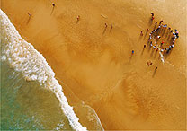 De parapente, fotgrafo foca pessoas jogando capoeira na praia do Santinho