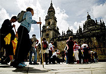 Peregrinos caminham em frente  catedral de Santiago, na Espanha