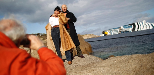 Casal tira foto na frente do Costa Concordia, na ilha de Giglio, na Itália - REUTERS/Tony Gentile